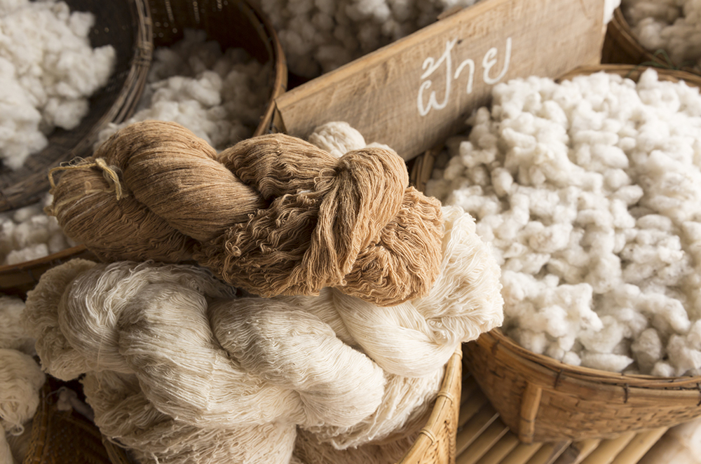 紡がれた糸の束と材料である大量の綿